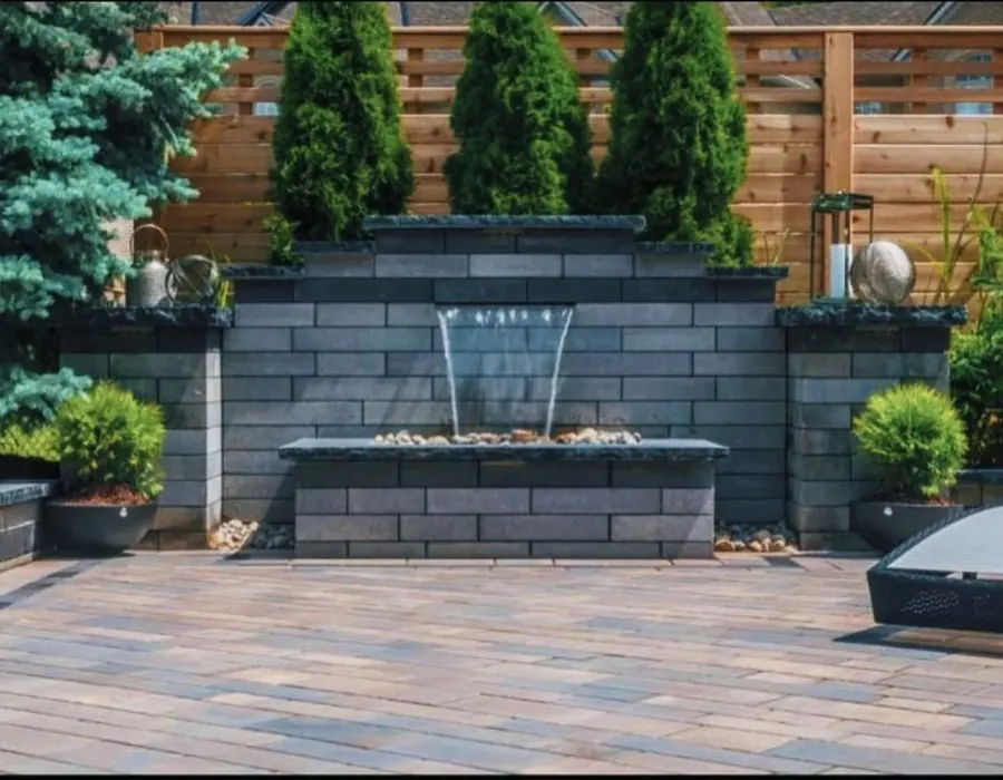 Custom stacked-stone water feature wall on a paver patio