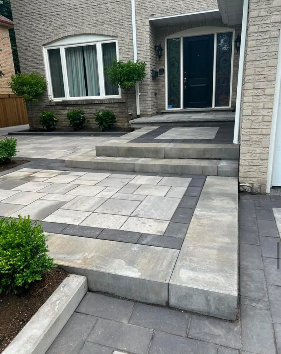 Paver walkway and front entry steps framed with potted greenery