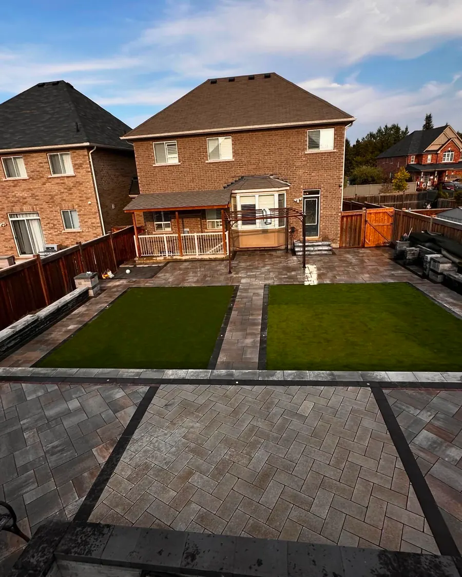 Aerial view of a full backyard build with paver patio, turf lawns and deck
