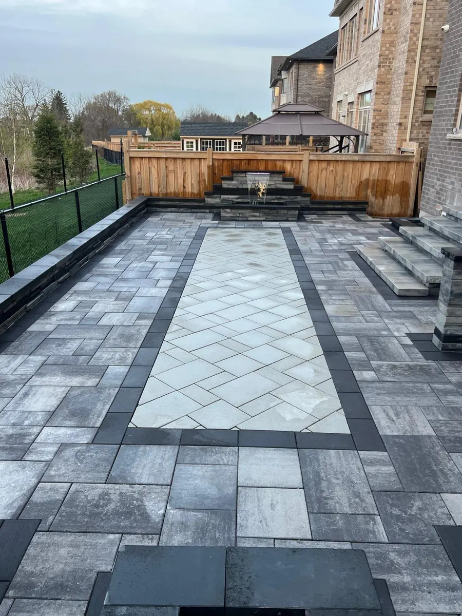 Paver patio with a diamond medallion inlay and stone fire feature