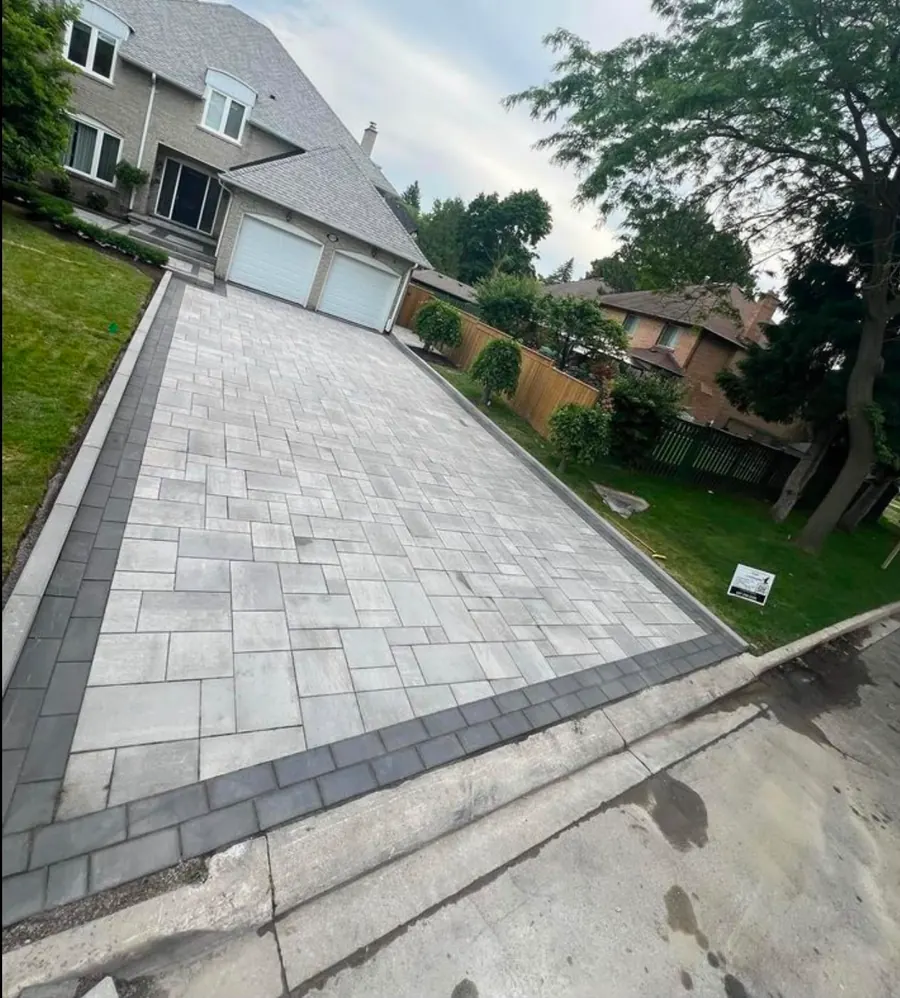 Herringbone paver driveway with a dark border and two-car garage