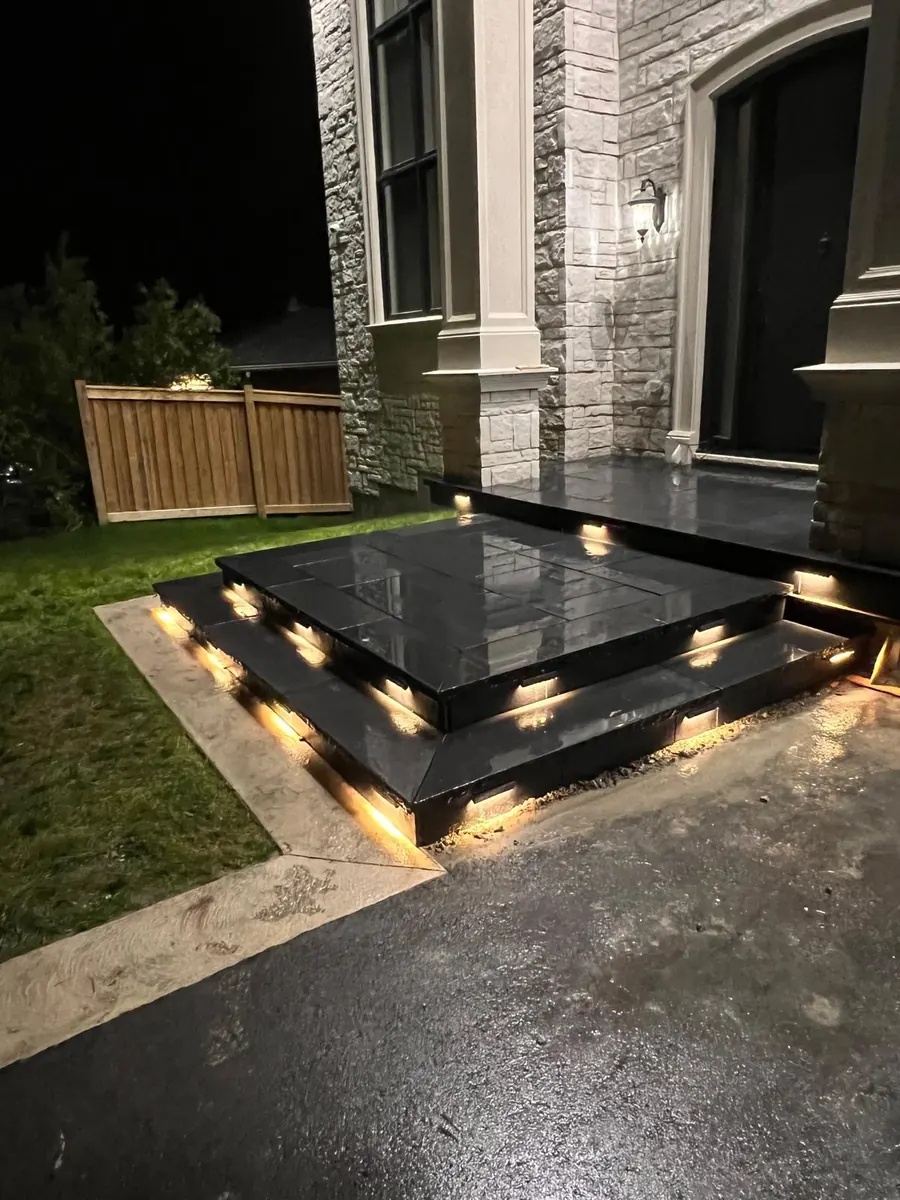 Black stone tiered steps with under-tread lighting at night