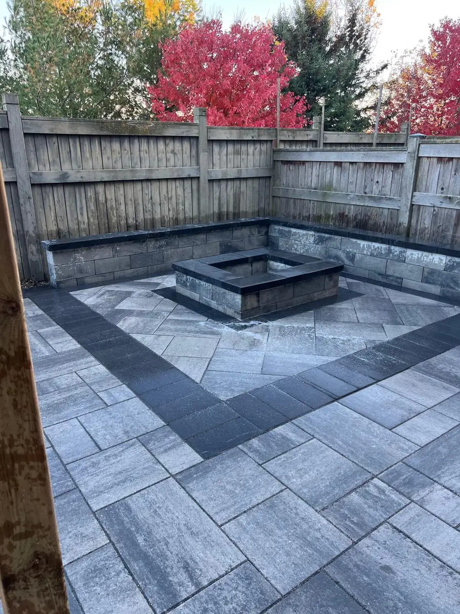 Corner fire pit and seat wall with a vivid red maple backdrop