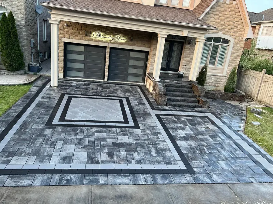 Two-tone paver driveway with a framed medallion and stone steps
